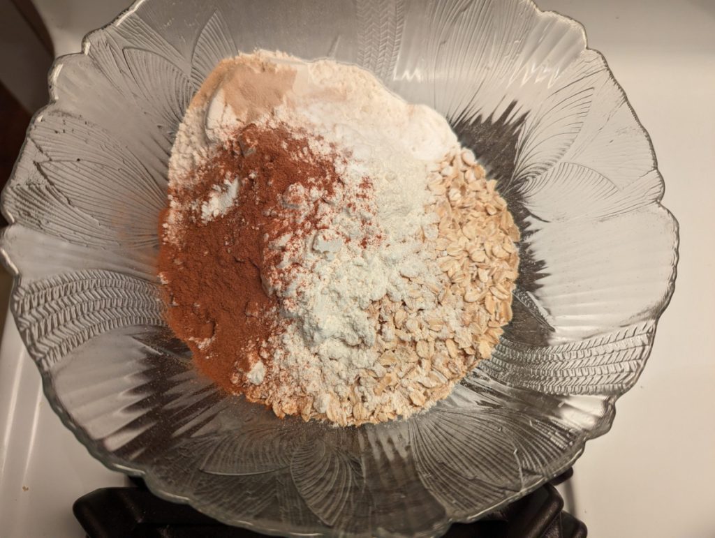 large bowl with oats, cinnamon, flour, brewer's yeast, and baking soda before mixing