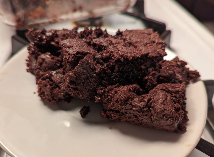 two pieces of vegan almond flour brownies on a white plate