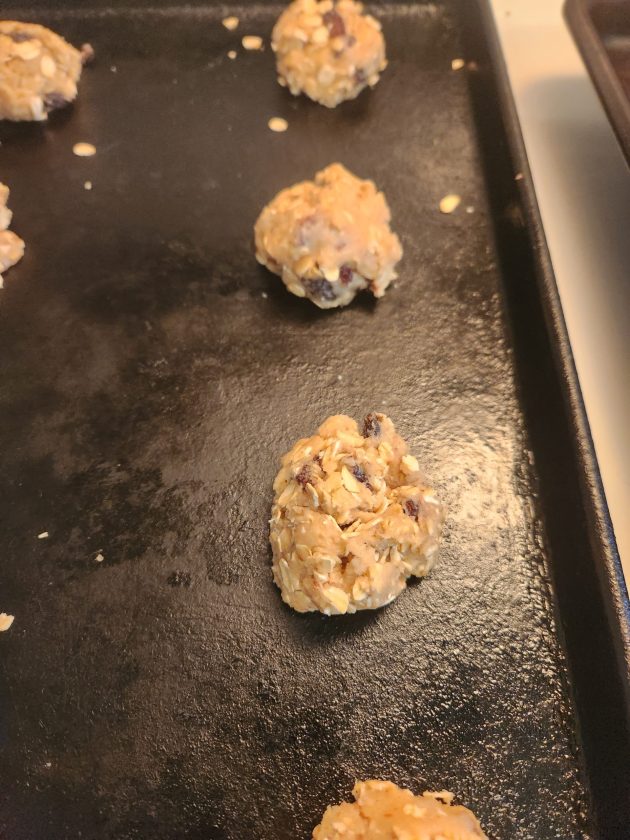cookie dough balls on black baking sheet