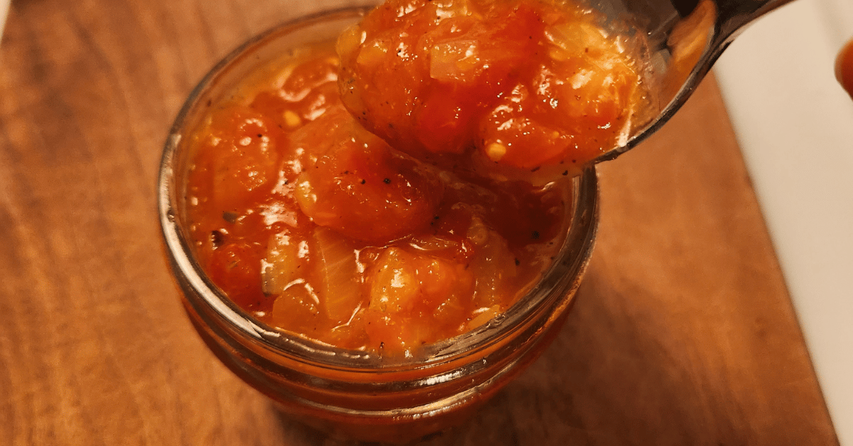 jar with tomato onion sauce and spoon