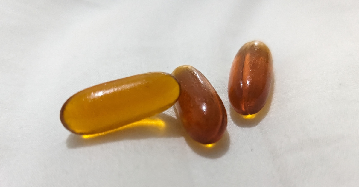 three soy lecithin capsules on white background